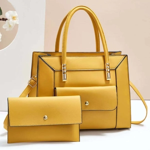 Detailed view of yellow tote bag set with matching wallet and golden hardware accents