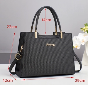 Detailed view of the black textured crossbody bag with dimensions 29x12x22cm and gold hardware