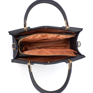 Detailed interior of a textured crossbody bag featuring three compartments and golden hardware