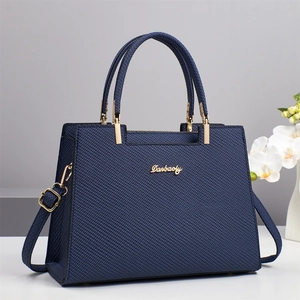 Detailed close-up of dark blue textured leather tote bag with gold metal Danbaoly logo