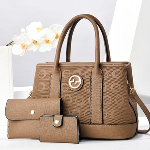 Detail of brown leather 3-piece bag set featuring perforated pattern and gold hardware
