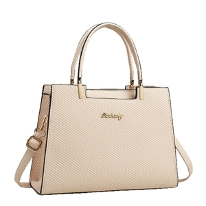 Beige textured crossbody bag with double handles and golden logo on white background