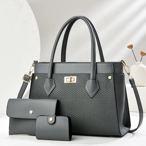 Detailed view of dark grey three-piece handbag set with textured weave and gold hardware