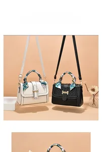 Close-up of contrast shoulder bag with silk scarf handle and metallic H-buckle