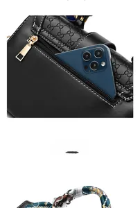 Detailed view of black embossed leather bag with gold hardware and phone storage pocket