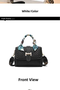 Close-up of black embossed handbag with gold buckle and silk scarf wrapped handle