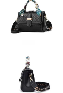 Detail view of black embossed handbag with printed silk scarf handle and wide strap