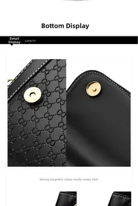 Detail of the golden magnetic buckle on black embossed leather with contrast stitching