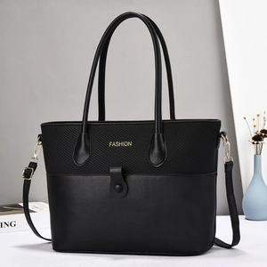 Détail du sac patchwork noir avec tissu texturé, cuir et lettrage FASHION doré élégant