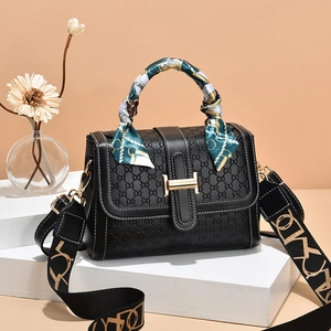 Black embossed leather handbag with silk scarf handle and wide geometric shoulder strap