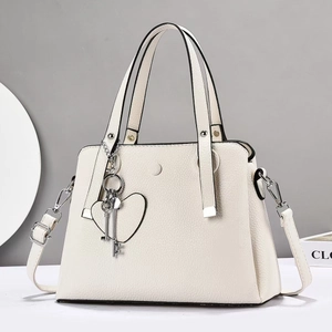 Borsa a mano beige in pelle martellata con ciondoli a chiave argentati e tracolla