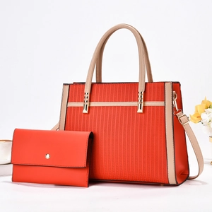 Detail of striped tote bag set with envelope wallet and gold hardware on white background