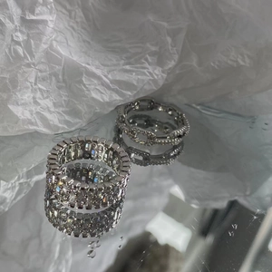 Close-up of hollow chain ring and wide band inlaid with cubic zirconia stones