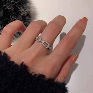 Close-up of silver hollow chain ring featuring pavé-set cubic zirconia on female hand