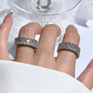 Detailed view of stacked silver rings with pave-set cubic zirconia on fingers