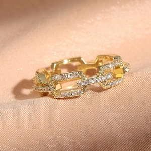 Modern gold hollow chain ring with shimmering pave zircons on soft pink satin fabric
