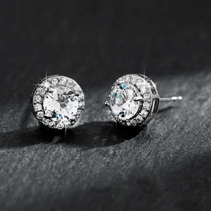 Sparkling silver halo stud earrings with round brilliant cut cubic zirconia on textured background