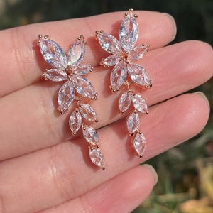 Close-up of elegant rose gold flower drop earrings with marquise cut cubic zirconia gems
