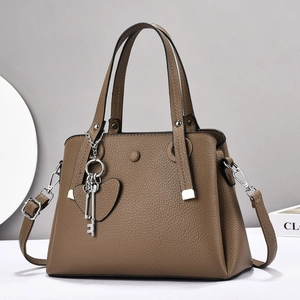 Brown lychee leather tote bag with top handles, heart charm and adjustable strap