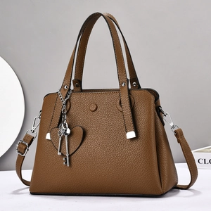 Brown textured leather handbag with dual handles and silver heart pendant decoration
