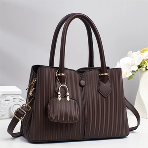Detail einer dunkelbraunen Falten-Ledertasche mit goldenen Beschlägen und Mini-Etui