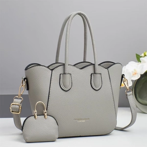 Detailansicht der grauen Litschi-Ledertasche mit Muschelrand und kleiner Zubehörtasche