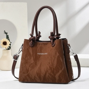 Detail der braunen Schultertasche mit Faltenstruktur, FASHION & BAG-Print und Knotengriff