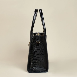 Vue latérale d'un sac cabas noir à texture lézard avec anneau en D doré brillant