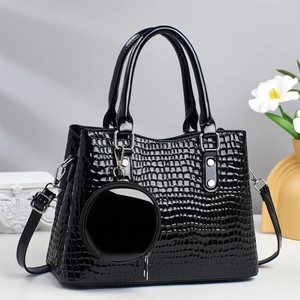 Close-up of black crocodile embossed patent leather tote bag with round coin purse