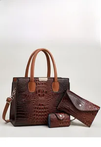 Detailed close-up of brown lizard pattern tote bag set with metal hardware accents