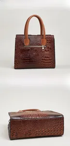 Rear view and wide base detail of brown faux crocodile leather handbag with metal zipper