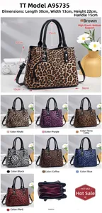 Detail view of large leopard print tote bag with round charm and internal compartments