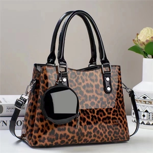 Détail d'un sac léopard en cuir verni avec finitions argentées et porte-monnaie