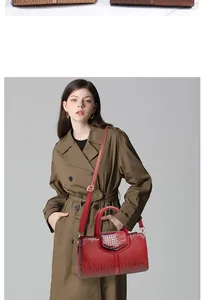 Model showcasing a large red crossbody bag with crocodile texture and elegant handle