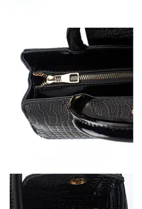 Detail of black crocodile pattern leather texture with premium golden zipper hardware