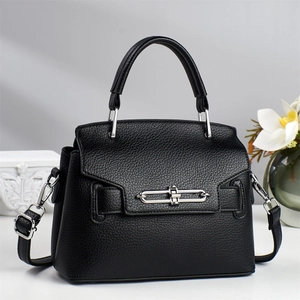 Detail of black litchi texture leather handbag with elegant silver magnetic buckle closure