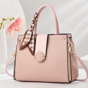 Pink tote bag detail with textured fabric, silk scarf handle, and golden D-ring hardware
