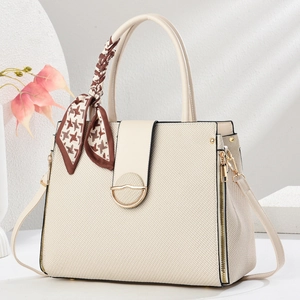 Detail of cream canvas tote bag with brown houndstooth scarf and golden metal twist lock