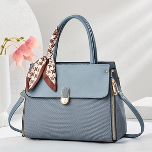 Elegant fog blue shoulder bag with scarf handle on a minimalist geometric background
