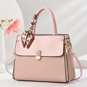 Detail of pink handbag with textured weave base and decorative houndstooth scarf on handle