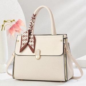 Detail of beige textured tote bag with houndstooth silk scarf and golden hardware buckle