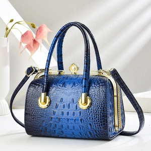 Detail view of crocodile pattern handbag with elegant pearl clasp and golden hardware