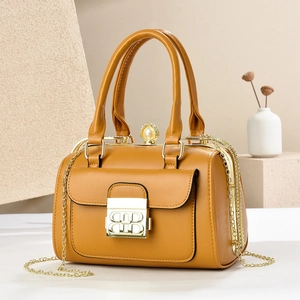 Detailed close-up of a mustard yellow faux leather evening bag with golden chain and pearl clasp