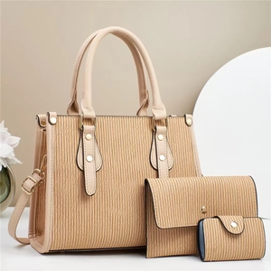 Close-up of khaki tote set with vertical wave embossed faux leather and gold hardware