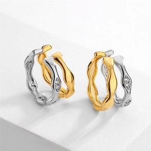 Chic irregular wavy gold and silver hoop earrings with zircon stones on white display