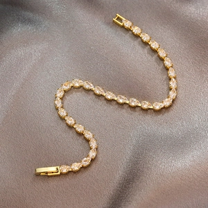 Detail eines vergoldeten Tennisarmbands mit birnenförmigen Zirkonia und Faltverschluss