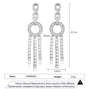 Detailed view of silver tassel earrings featuring pave-set zircon circles and long fringe