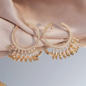 Elegante goldene Sonnenstrahl-Ohrringe mit Zirkonia-Steinen auf Seidenstoff