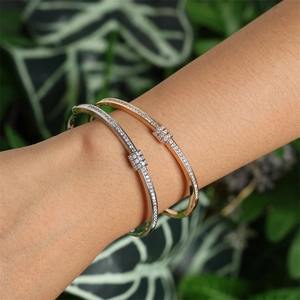Gros plan de bracelets dorés et argentés avec oxydes de zirconium et nœud carré chic