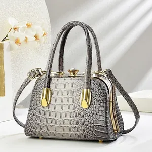 Detail of grey crocodile pattern evening bag with crystal clasp and gold handle
